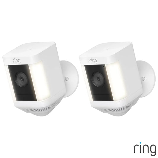 A pair of matte white Ring Battery Spotlight Cam Plus outdoor security cameras mounted to a clean exterior wall, showing the dual LED spotlights and wide-angle camera lens.