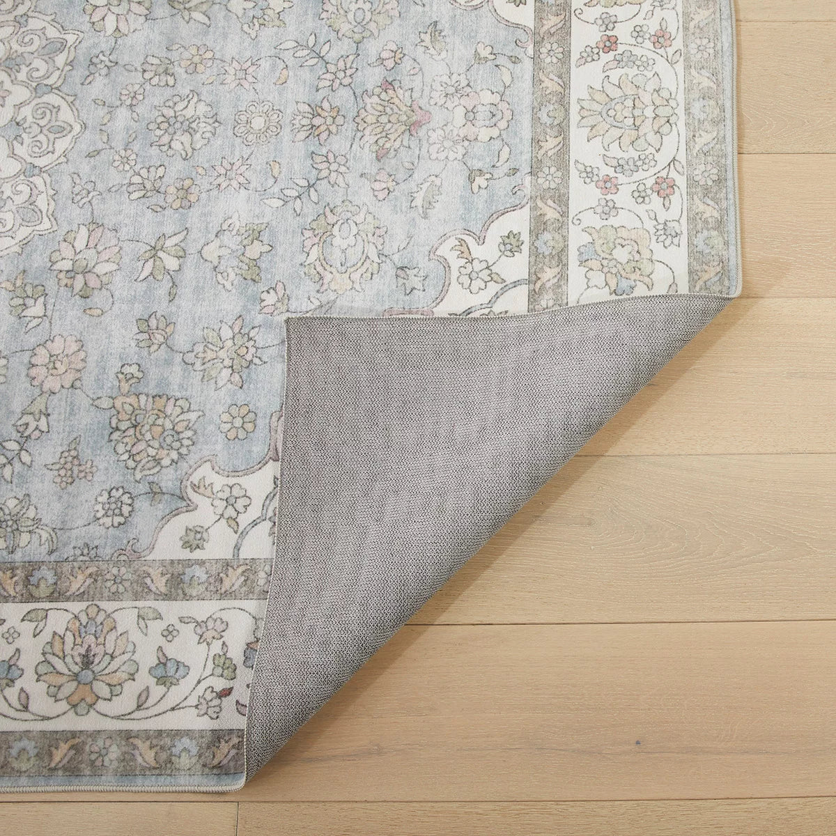 Top-down view of the Concept Looms Liberty Blue Washable Rug showcasing its rich blue vintage pattern and velvet short-pile texture on light hardwood flooring.