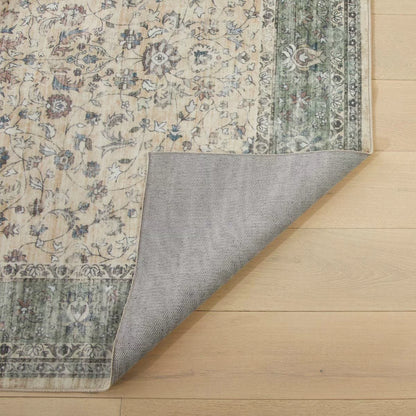 Angle view of the cream and green floral Concept Looms Liberty Washable Rug showing its plush velvet texture and short 4mm pile on a dark laminate floor.