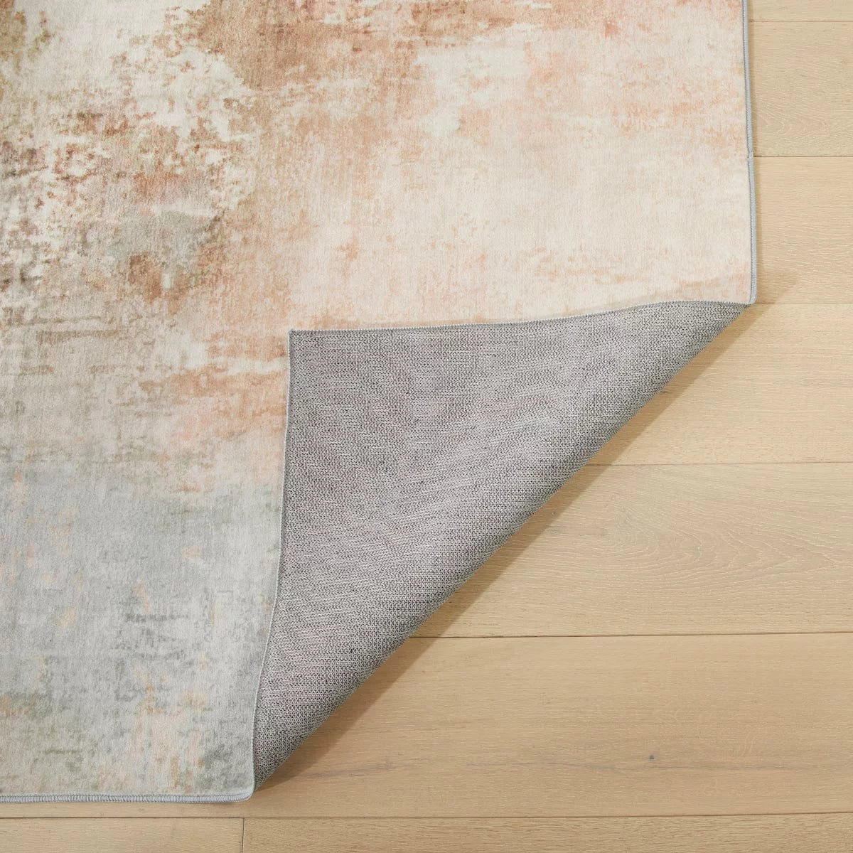 Top-angle view of the plush Concept Looms Liberty Spring Washable Rug laid out on a polished hardwood floor in a brightly lit modern living room setting.