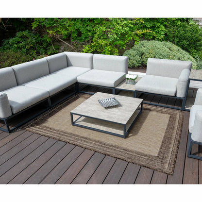 Concept Looms Sumac beige and brown textured flatweave rug styled on a sunny outdoor patio floor.