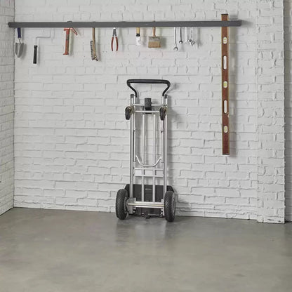 Black and silver Cosco 3-in-1 aluminium hand truck configured in the 4-wheel flatbed position showing the durable flat-free wheels on a smooth industrial concrete surface.