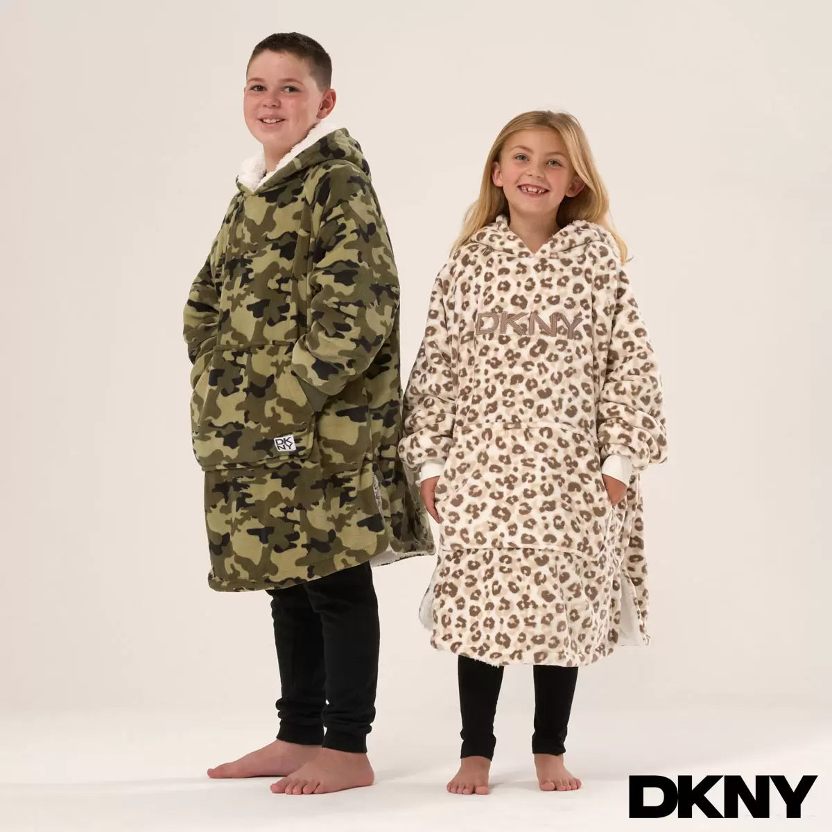 Front view of a plush black DKNY kids oversized hoodie displaying the fluffy sherpa fleece interior lining and front kangaroo pocket on a clean neutral background.