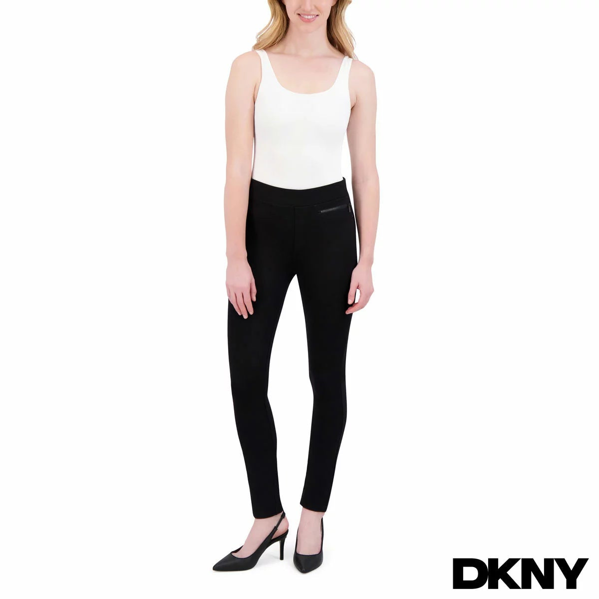 Side view of a model wearing black plaid DKNY ladies pull on ponte pants with front zipper details and skinny leg fit.
