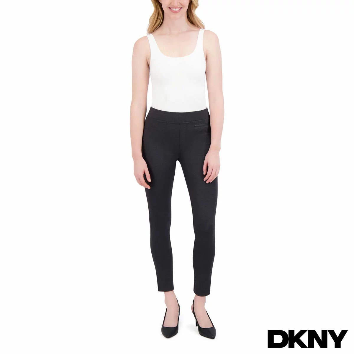 Side view of a model wearing black plaid DKNY ladies pull on ponte pants with front zipper details and skinny leg fit.