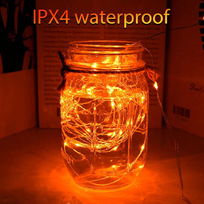 A 3M flexible silver wire string with 30 amber orange LEDs glowing warmly around an autumn fireplace display