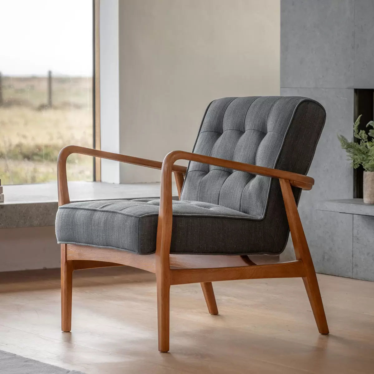 Dark grey linen armchair with wooden frame and deep cushioned seat designed for modern living room comfort