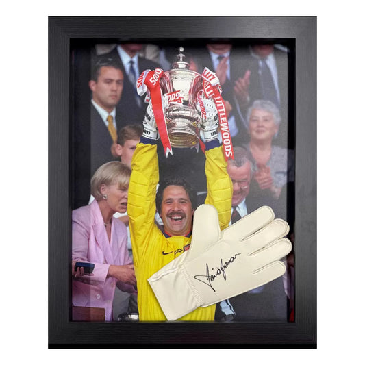 A framed, authentic Adidas goalkeeper glove signed by David Seaman, displayed against a dark background with a certificate of authenticity visible.