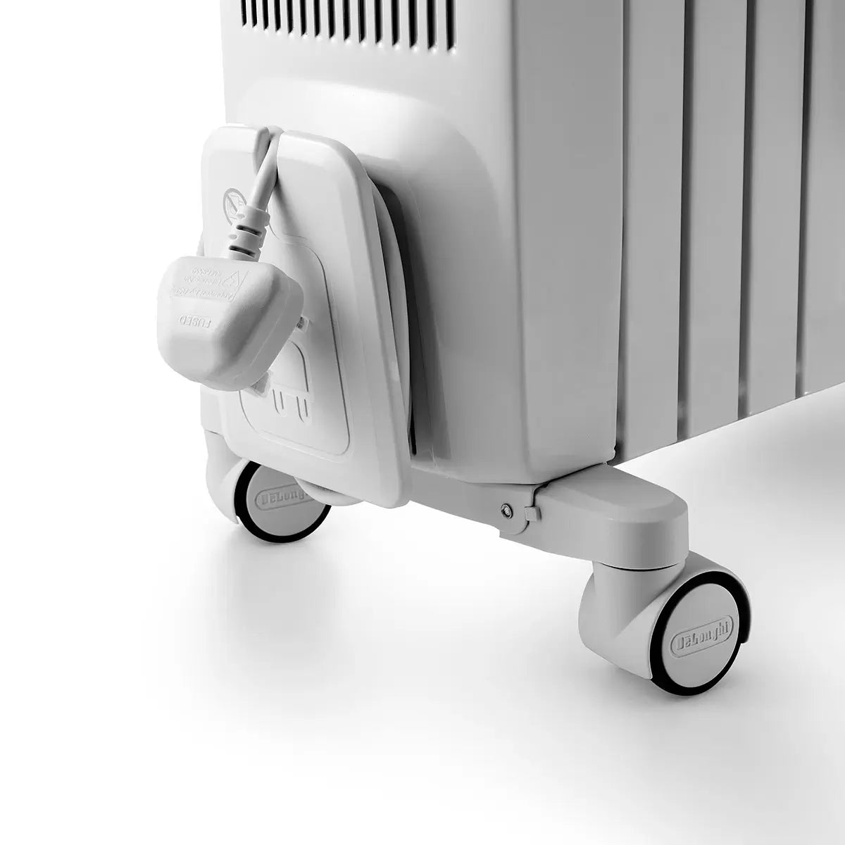 Front three-quarter view of the white De'Longhi Dragon 4 oil-filled radiator standing on a wooden floor showing the digital LED display screen and side chimney fins.