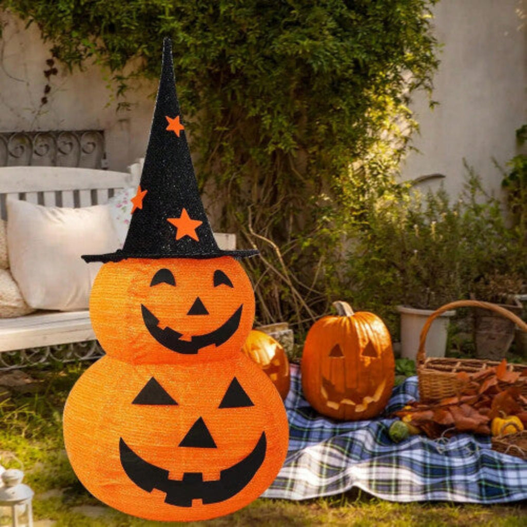 A deep sapphire collapsible fabric Jack-o-lantern pumpkin light displayed on a decorated outdoor porch step.