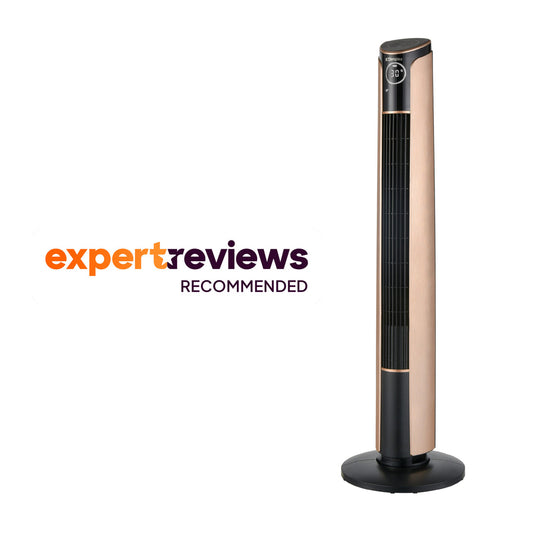 A tall, slender black and copper Dimplex Ion Fresh tower fan standing elegantly on a hardwood floor next to a modern armchair.