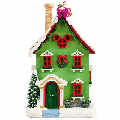 Complete 13-piece lighted Disney Christmas village featuring hand-painted Mickey Mouse figures, glowing LED snow-covered houses, and illuminated archway on a wooden table.