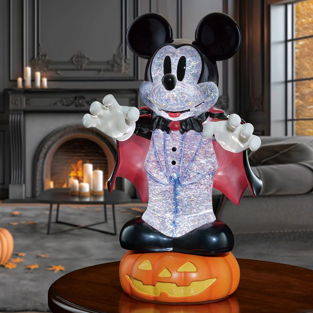 A 16-inch black Disney Halloween lantern displaying intricate character sculptures inside a liquid-filled chamber with glowing orange LED lights and swirling gold glitter sparkles, captured from a front eye-level perspective.