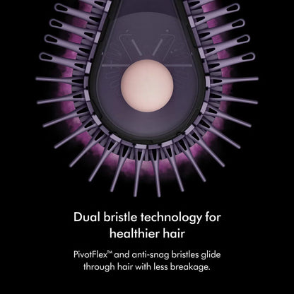 Dyson Airsmooth styling brush in Ceramic Pink with teardrop brush head and soft dual bristles sitting on a vanity table.
