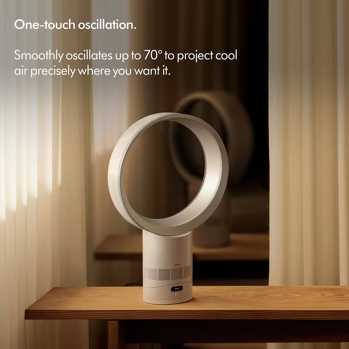 Sleek white and nickel Dyson Cool CF1 desk fan AM12 showing its open bladeless amplifier loop atop a minimalist wooden desk.