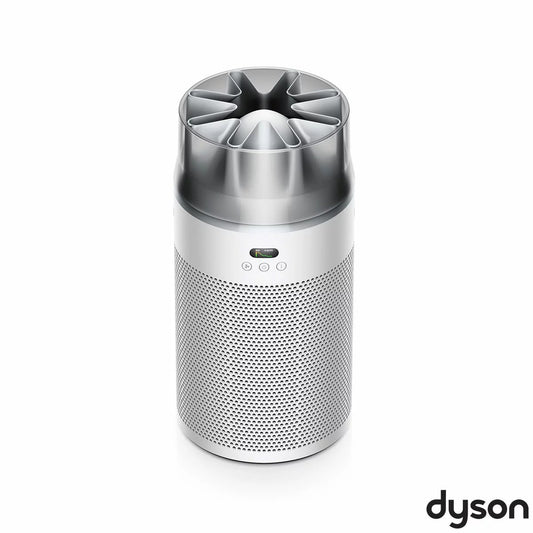 Compact white Dyson HushJet HJ10 air purifier sitting on a wooden bedside table beside an illuminated lamp.