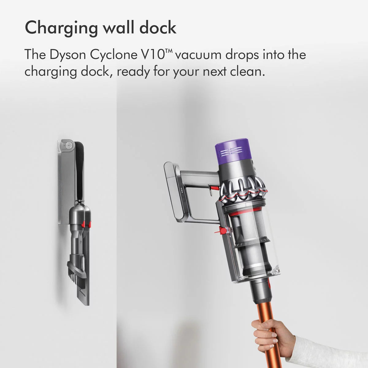 Profile view of the nickel and copper Dyson V10 Submarine cordless wet and dry vacuum cleaner upright on its wall dock with the Submarine wet roller attached.