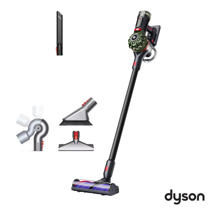 Side angle view of the nickel and iron Dyson V8 Cyclone Cordless Stick Vacuum held upright with the furniture cleaning kit accessories attached.