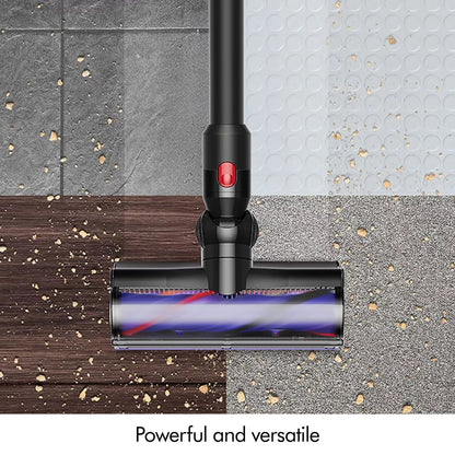 Side angle view of the nickel and iron Dyson V8 Cyclone Cordless Stick Vacuum held upright with the furniture cleaning kit accessories attached.
