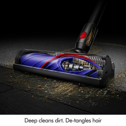 Dyson V8 Cyclone stick vacuum cleaner in use on carpet, removing pet hair and dust with powerful cordless suction technology.