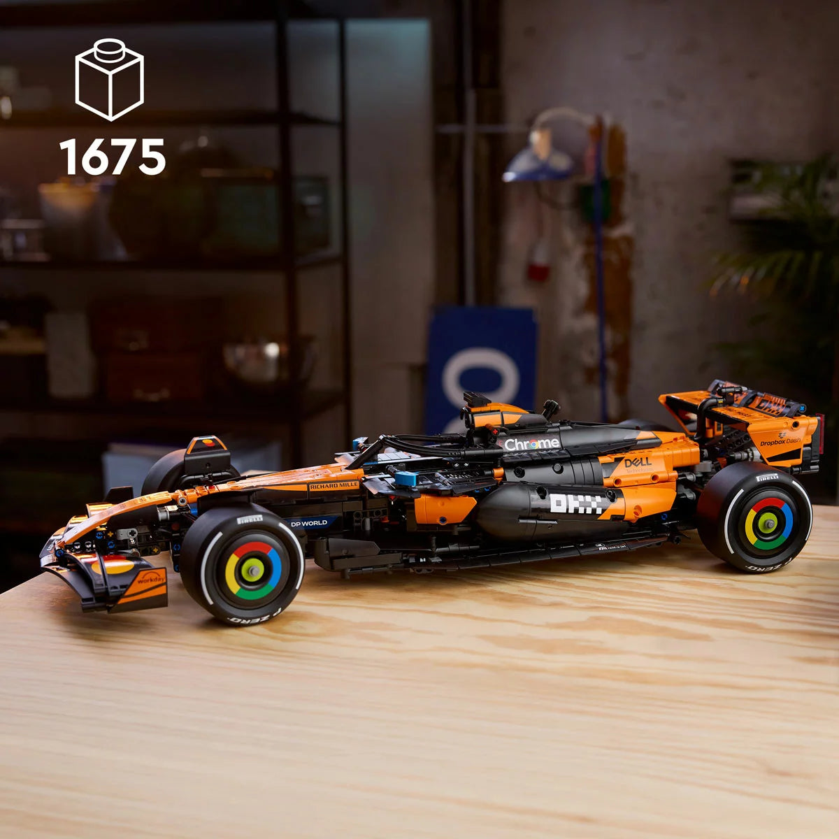 Three-quarter overhead shot of the massive built papaya orange and black LEGO 42228 McLaren Formula 1 racing car model displayed on a gray surface.