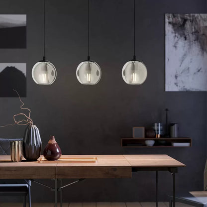 Three smoked glass ball pendant light fixture with modern black frame, suspended for ambient dining room lighting