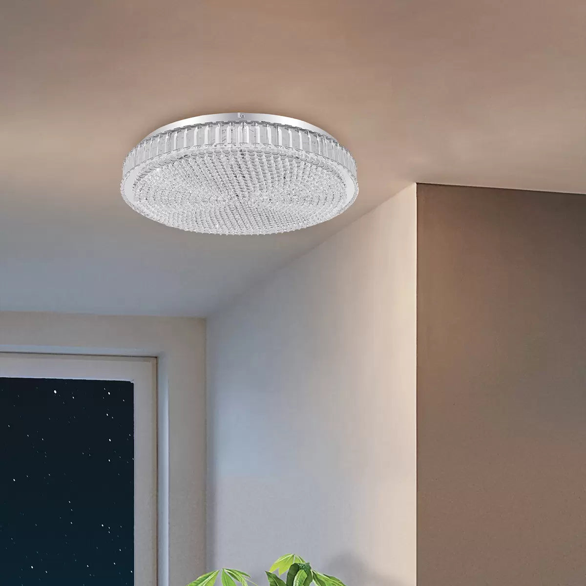 Top-down close-up of the circular Eglo Balparda flush ceiling light featuring polished chrome metal trim and hundreds of small, clear glass crystals refracting light in a modern bedroom setting.