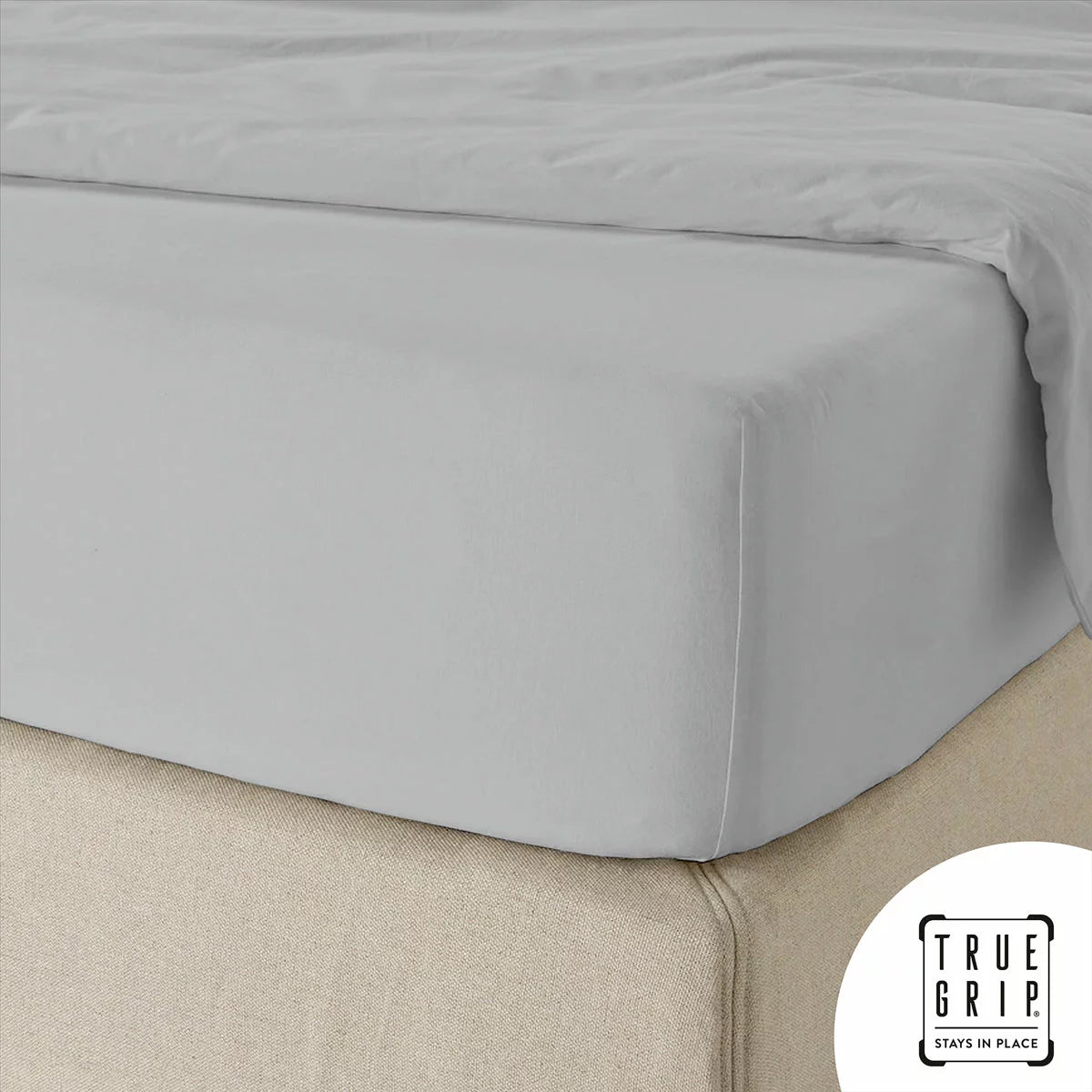 A close-up overhead shot of a neatly tucked Purity Home charcoal grey 400 thread count cotton fitted sheet stretched tightly over a deep mattress corner.