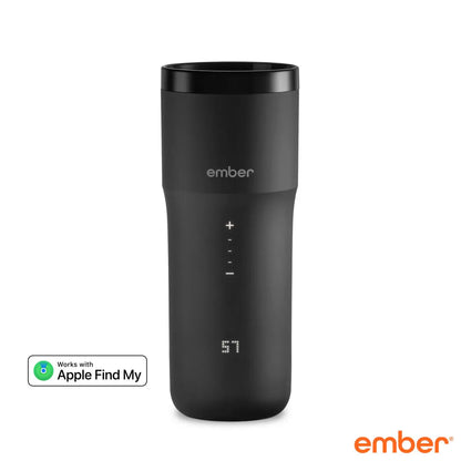 Matte black Ember Temperature Control Travel Mug 2+ with illuminated digital touch display resting on its charging coaster on a wooden office desk.