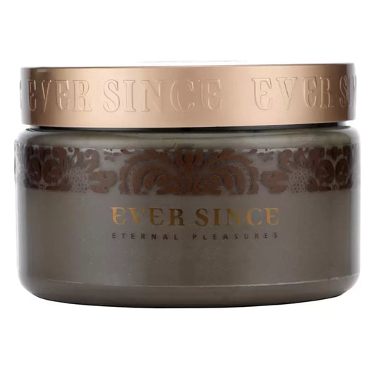 A 500g container of Ever Since Dead Sea Mud Mask positioned on a stone ledge next to a pile of soft linen towels, showing the rich, dark earthy texture of the product.