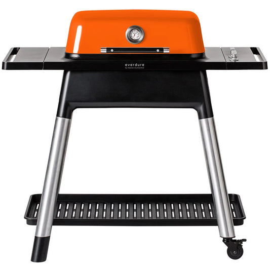 Vibrant orange Everdure Force 2 burner gas barbecue with hood open displaying cast iron grills on a modern outdoor patio.