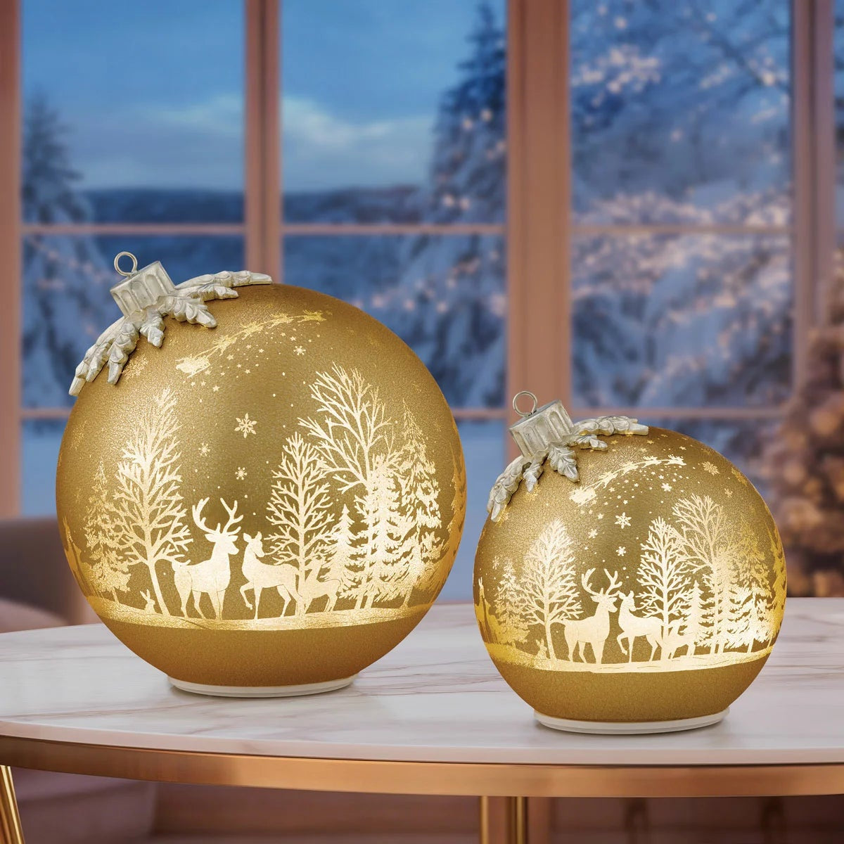 Pair of illuminated frosted glass rotating ball ornaments featuring etched reindeer and winter forest scenes glowing on a modern mantelpiece.