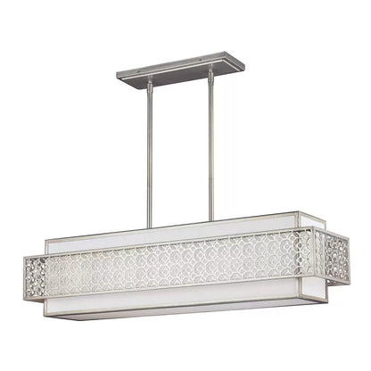 A horizontal five-light Feiss Kenney island chandelier with a sunrise silver geometric steel frame overlaying a white linen shade, suspended above a modern dining table.