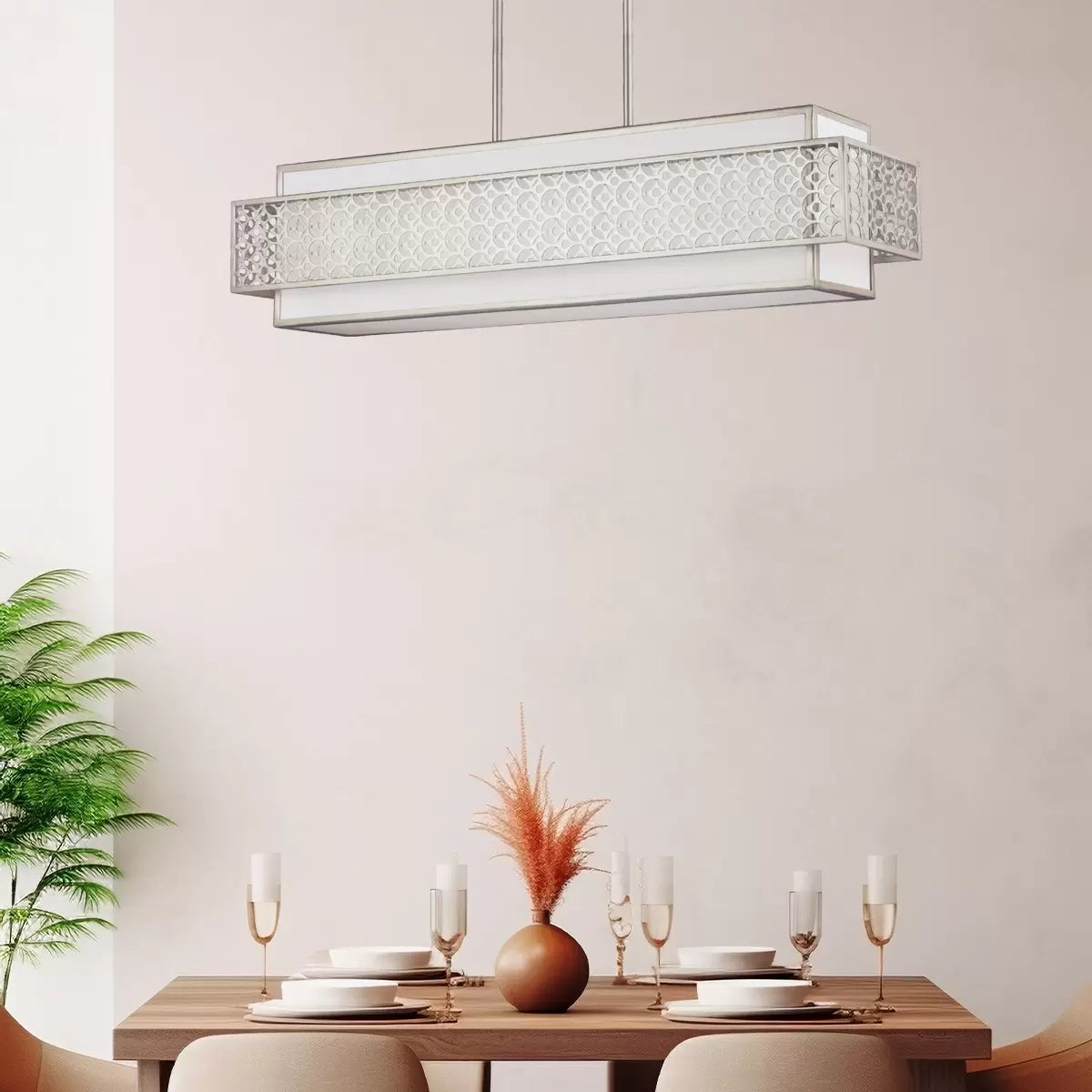 A horizontal five-light Feiss Kenney island chandelier with a sunrise silver geometric steel frame overlaying a white linen shade, suspended above a modern dining table.