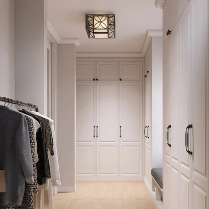 Low-profile Feiss Remy flush-mount ceiling light featuring a dark heritage bronze iron frame, a glittering Parisienne gold metal ring, and a warm bronze organza shade.