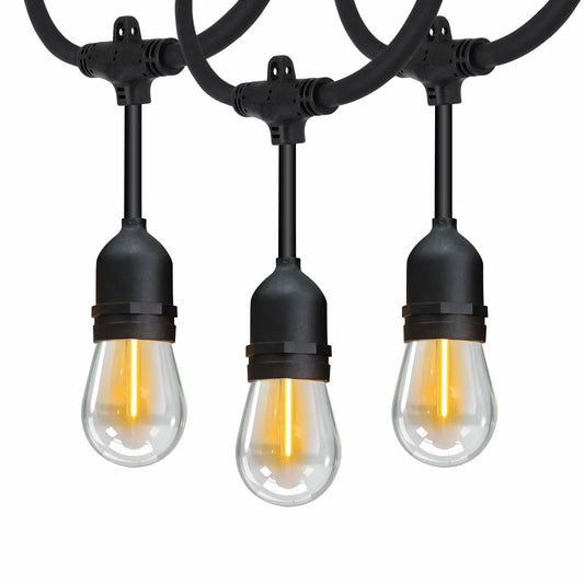 A 48ft strand of Feit LED string lights with warm glowing vintage-style bulbs hanging across a dark backyard patio.