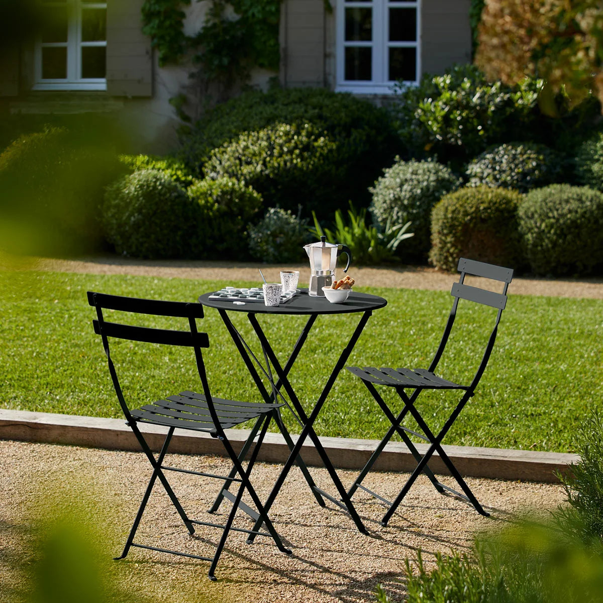 Authentic 3-piece Fermob Bistro set in a sophisticated grey finish, styled on a contemporary concrete patio.