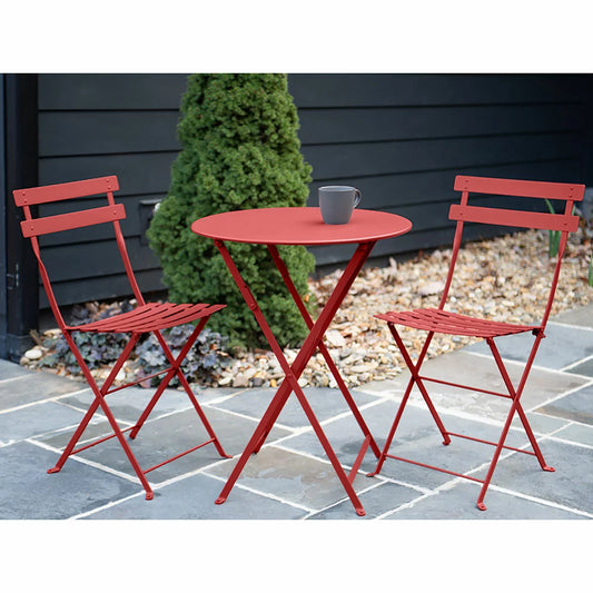 Authentic 3-piece Fermob Bistro set in vibrant red, styled on a modern patio with lush green surroundings.