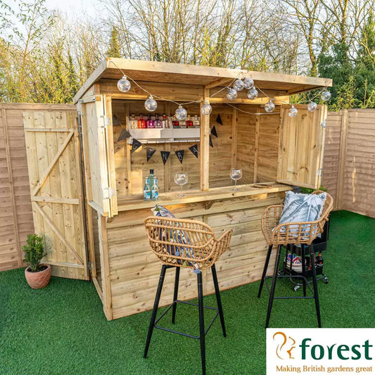 Forest Garden 6ft x 3ft wooden bar shed with open bifold shutters and a wooden bar top, set up in a lush garden.