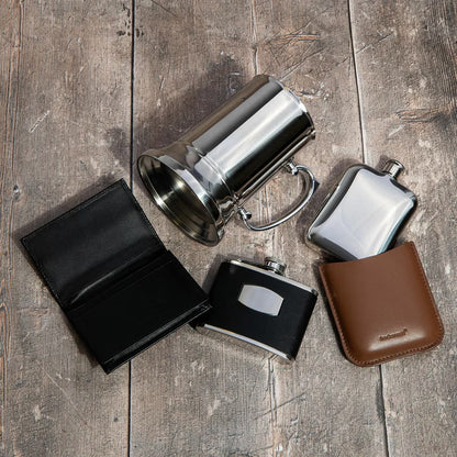 Front angle view of a silver Fred Bennett 580ml stainless steel tankard featuring a black leather wrap and a sturdy zinc alloy handle on a wooden bar desk.