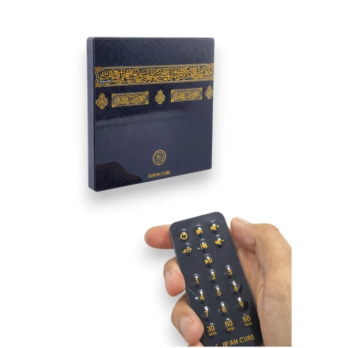 Front view of the sleek white Quran Magnet speaker mounted on a stainless steel refrigerator door with its wireless remote control resting nearby.