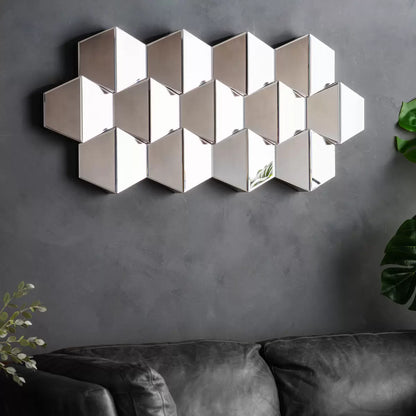 Front view of the 50x110cm Gallery Carina geometric wall mirror showing silver hexagonal honeycomb facets mounted on a neutral wall.