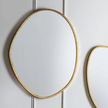 Vertical Gallery Chattenden gold pebble mirror mounted on a neutral living room wall reflecting natural light.