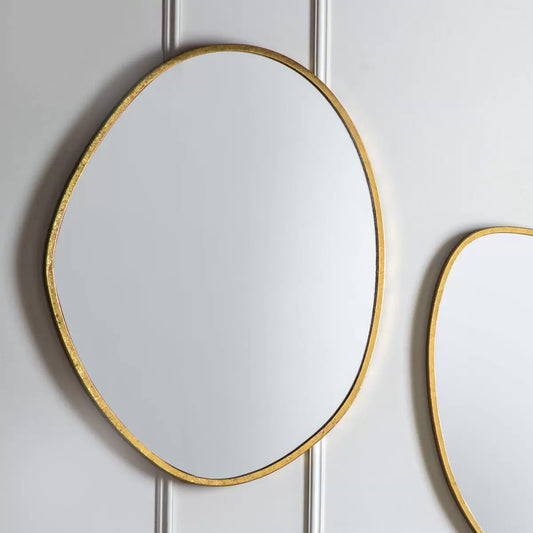 Vertical Gallery Chattenden gold pebble mirror mounted on a neutral living room wall reflecting natural light.