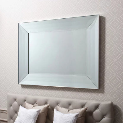 Gallery Ferrara rectangular mirror measuring 91 by 122 cm with a wide bevelled mirror frame and silver edge mounted horizontally above a neutral hallway console table.
