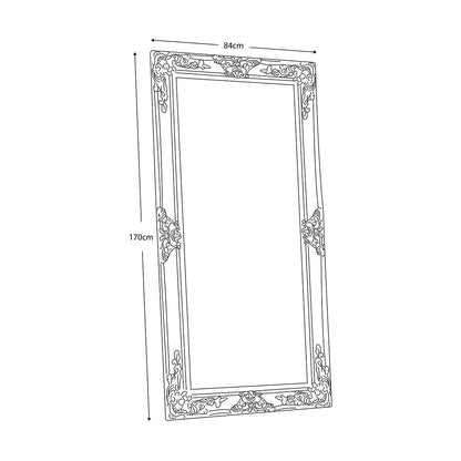 Full-length Gallery Hampshire antique silver leaner mirror with baroque wooden carved frame propped against a neutral living room wall.