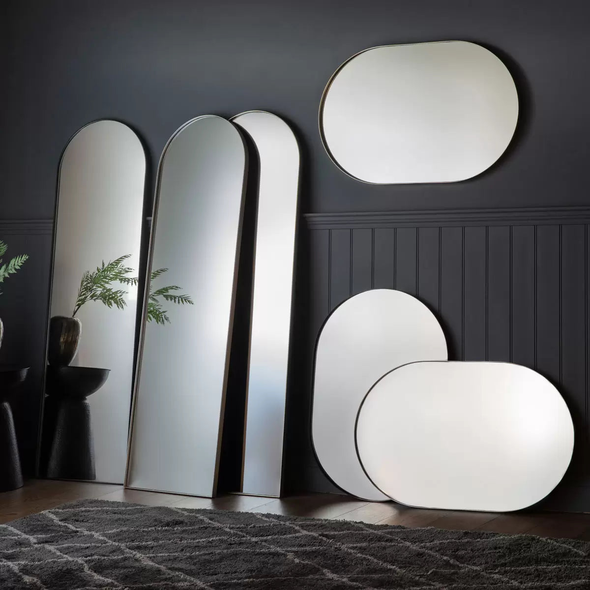 Front view of the Gallery Hurston Elipse Black Mirror showing its smooth curved iron frame and 60x90cm oval silhouette mounted on a minimalist wall.