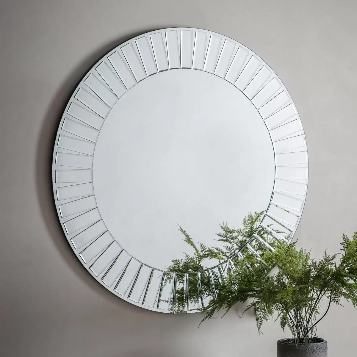Gallery Mondello 90cm round wall mirror featuring an intricate mosaic border of bevelled glass pieces mounted on a modern living room wall.