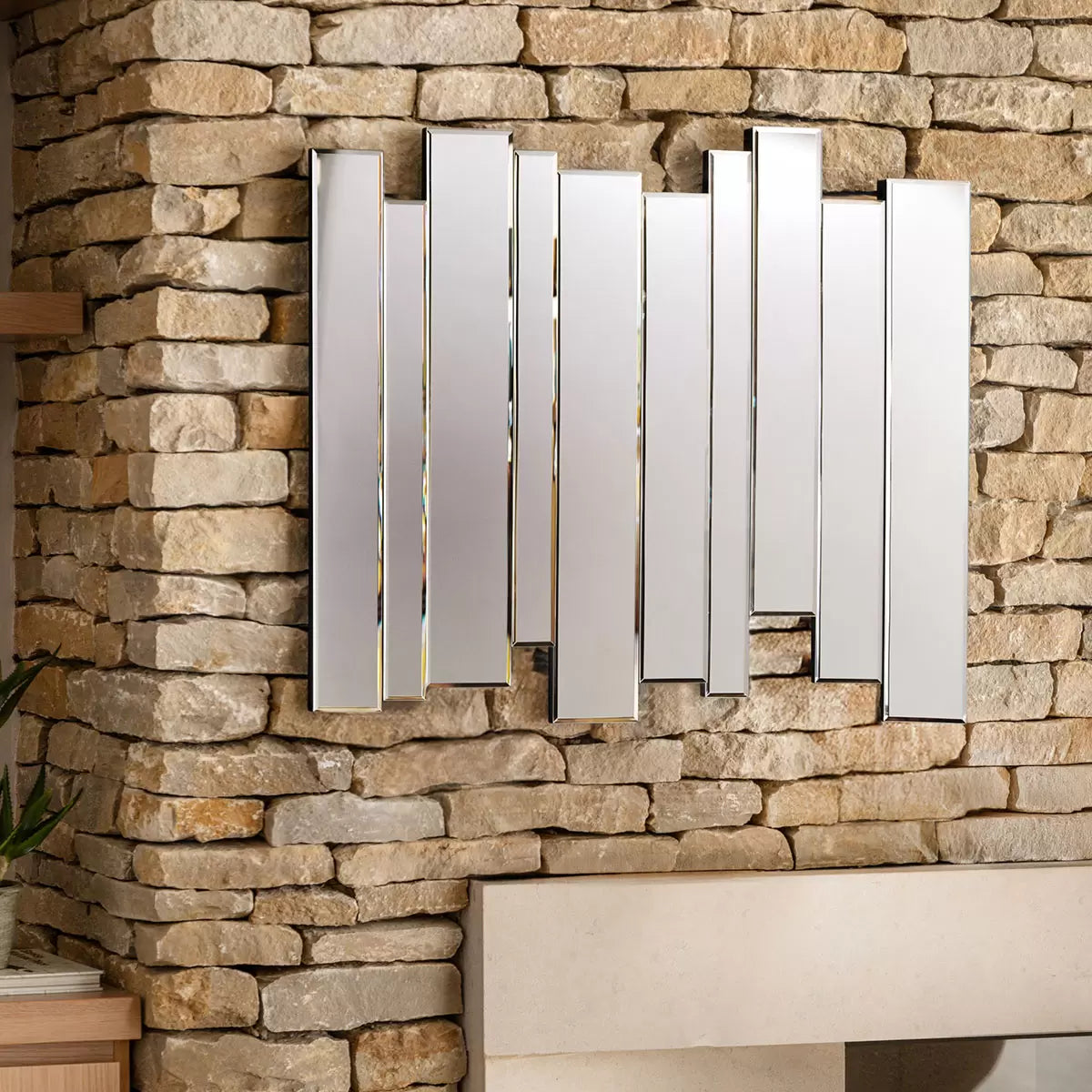 Front view of the Gallery Montessa 70 x 80cm wall mirror showing staggered bevelled glass panels mounted vertically on a neutral living room wall.