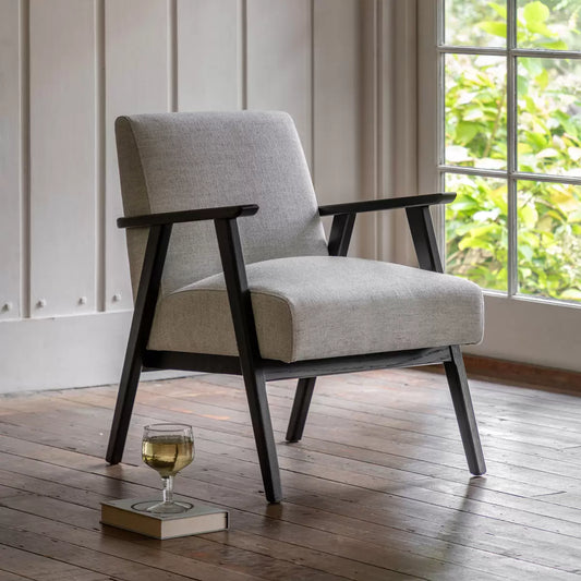 Front angle view of the Gallery Neyland Armchair upholstered in textured mottled stone linen set against a modern neutral backdrop.